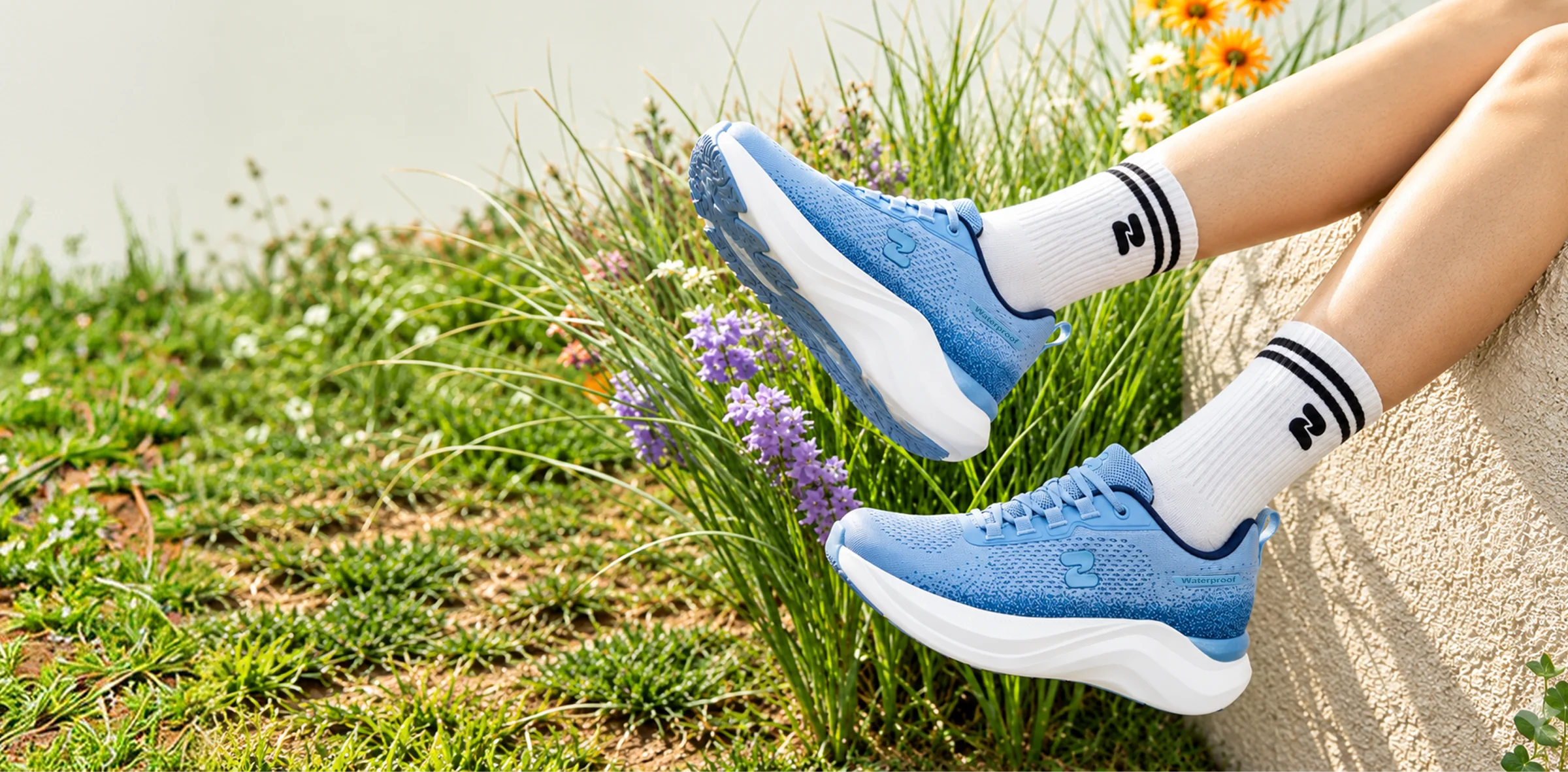 Blue OSZEA shoes outdoors among spring flowers